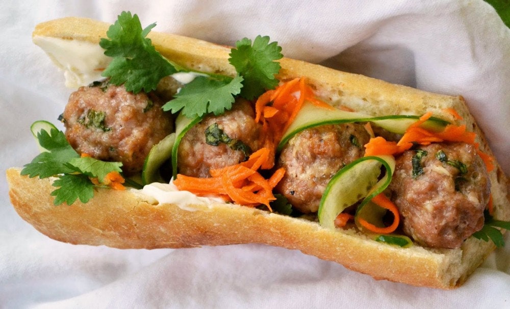 A banh mi perfectly balances meat fillings, sauce, fresh vegetables, and pickled ingredients